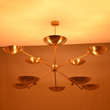 Night view of brass bowl chandelier illuminated with warm indirect lighting across all ten bowl shades.