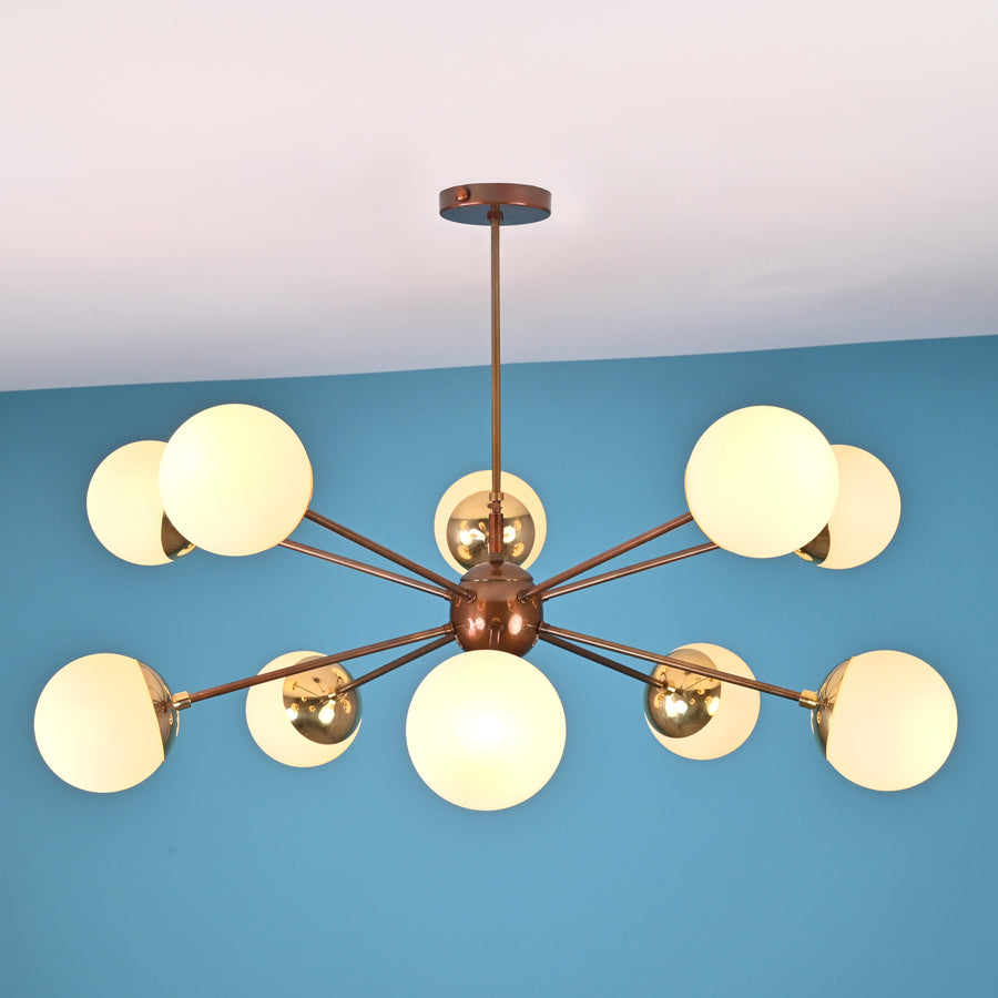 Front elevation of a 10 light brass globe chandelier featuring a central sphere and balanced mid century modern design.