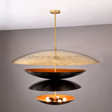 Front angle of illuminated 10-light layered disc chandelier with warm inner glow and contrasting black and gold brass bowls.