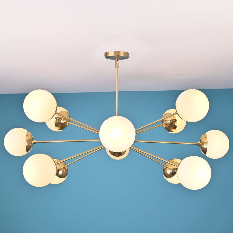 Modern 12 light brass globe chandelier with opal glass shades and symmetrical mid century design