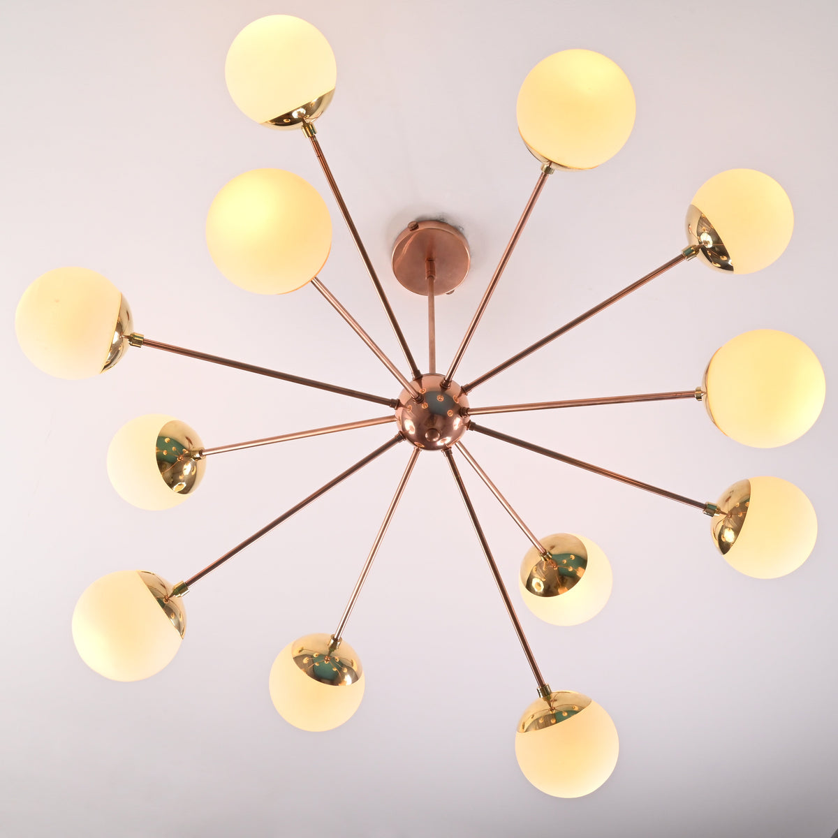 Bottom view of 12 light opal glass brass sputnik chandelier with radial arms and globe shades