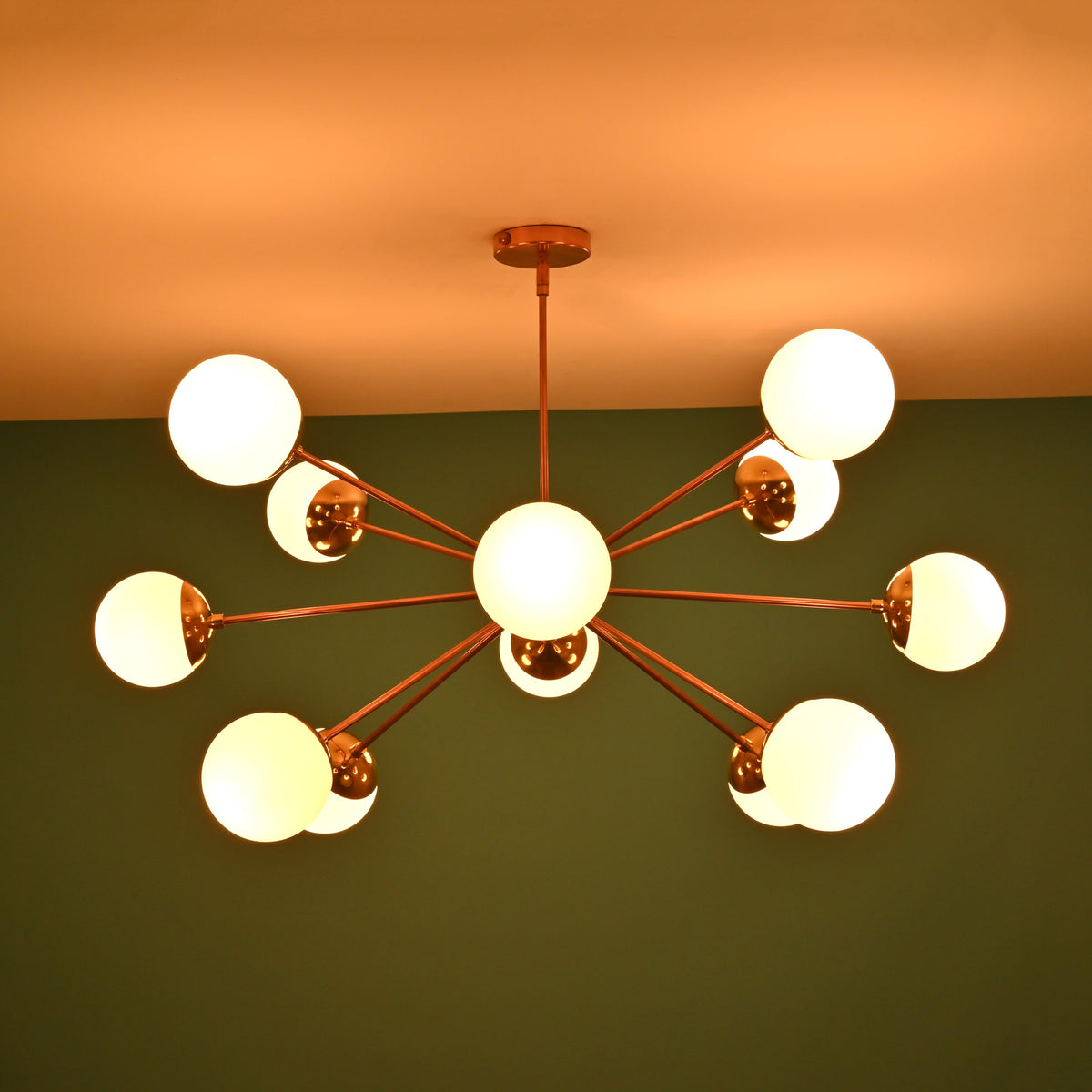 Handmade 12 opal glass brass chandelier producing soft ambient glow with mid century modern aesthetic