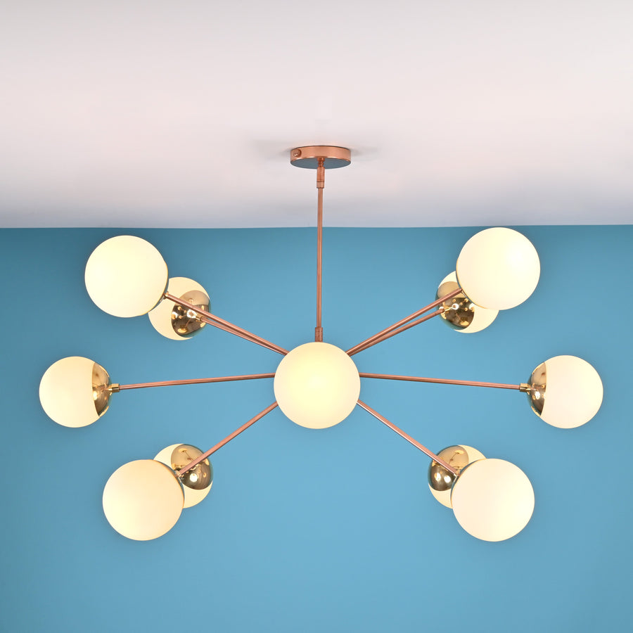 12 opal glass sputnik chandelier in solid brass with mid century modern radial design, warm ambient ceiling lighting