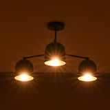 Close-up view of a brass bowl shade chandelier showing warm light diffusion and glow.