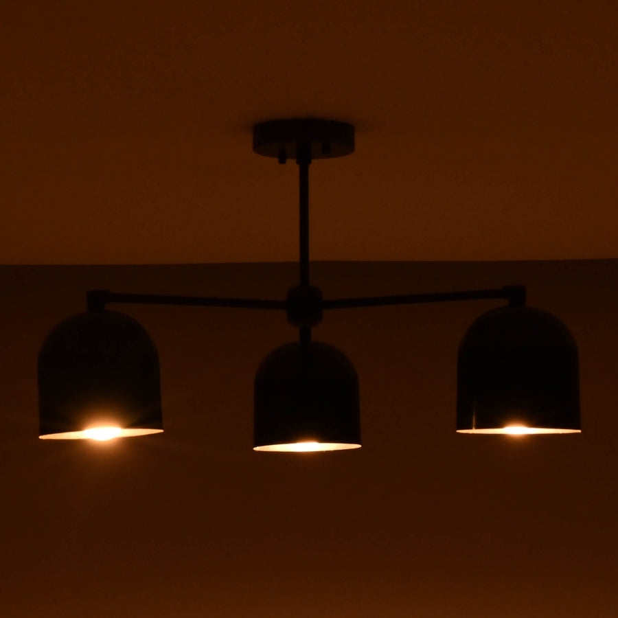 Front view of a 3 light brass bowl shade chandelier with black finish and warm interior glow.