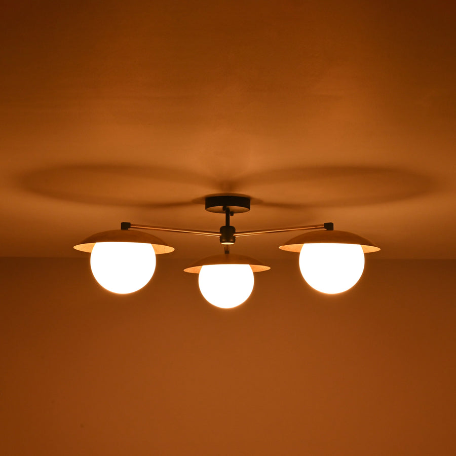 Front view of 3 light brass disc flush mount ceiling light with opal glass globes and modern industrial design.