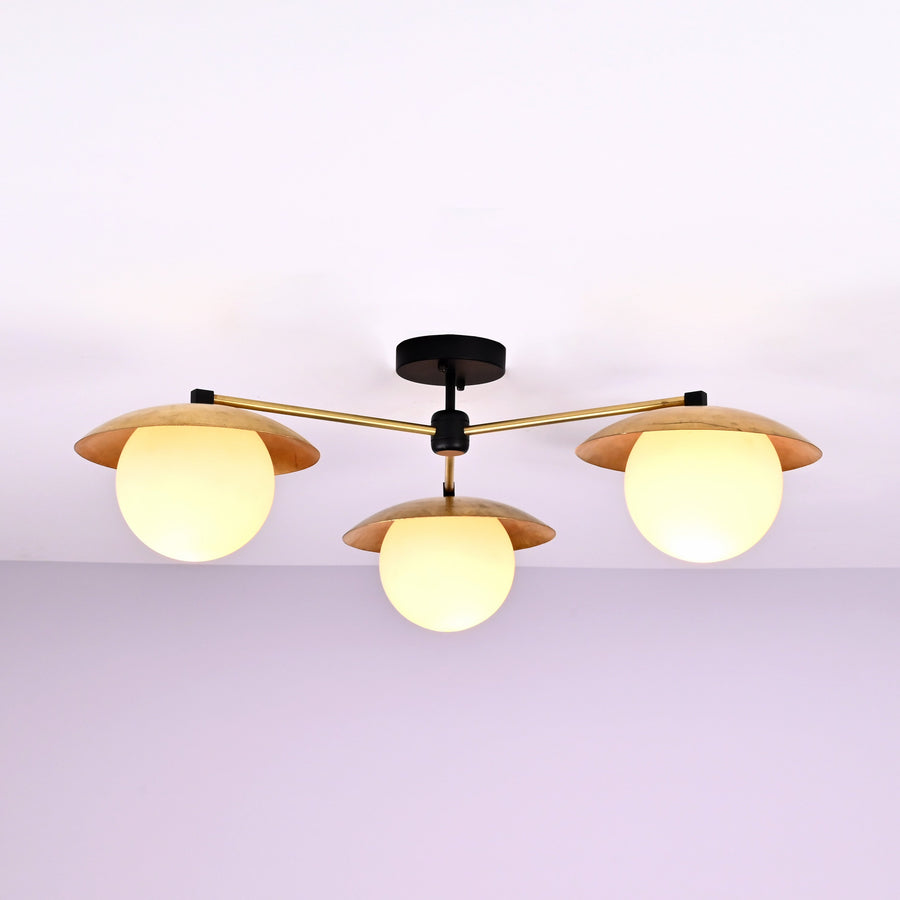 Front view of 3 light brass disc flush mount ceiling light with opal glass globes and modern industrial design.