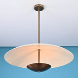 3 light disc style brass chandelier illuminated with warm ambient indirect lighting