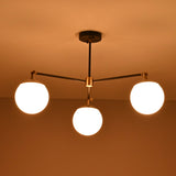 Bottom view of a 3 light opal glass globe chandelier highlighting balanced arms and glowing spheres.
