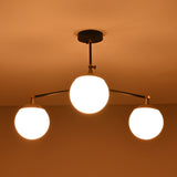 Opal glass globe brass chandelier creating a warm, ambient ceiling glow in a modern space.