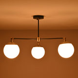 Dramatic low-light scene showcasing the warm glow of an opal glass globe brass chandelier.