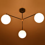 Evening view of a brass chandelier with opal glass globes casting soft, warm light.