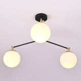 Symmetrical layout of a handcrafted 3 light opal glass globe chandelier with minimalist brass detailing.