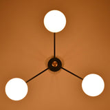 Three light opal glass globe chandelier illuminated with warm ambient lighting in a cozy interior.