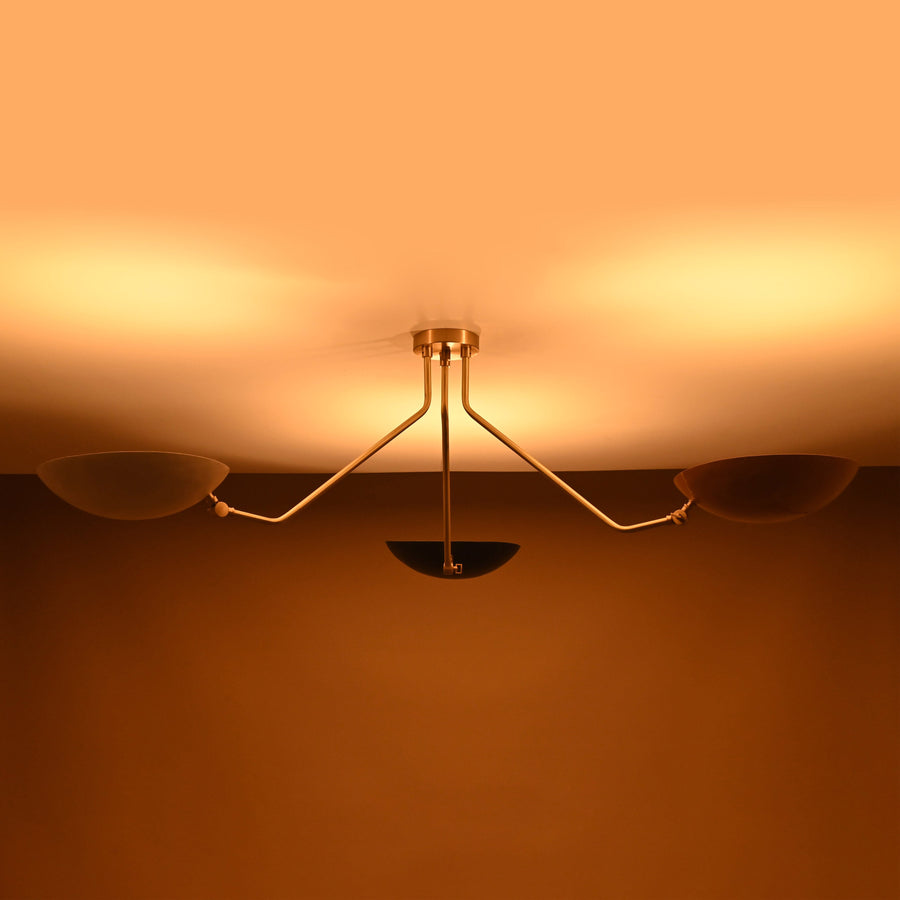 Three-arm brass chandelier with white, black, and beige bowl shades — contemporary flushmount lighting