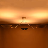 Contemporary brass three-arm ceiling light with reflective bowl shades — warm ambient glow