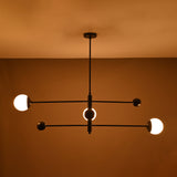 Modern matte black orb chandelier glowing with warm ambient light – centered view