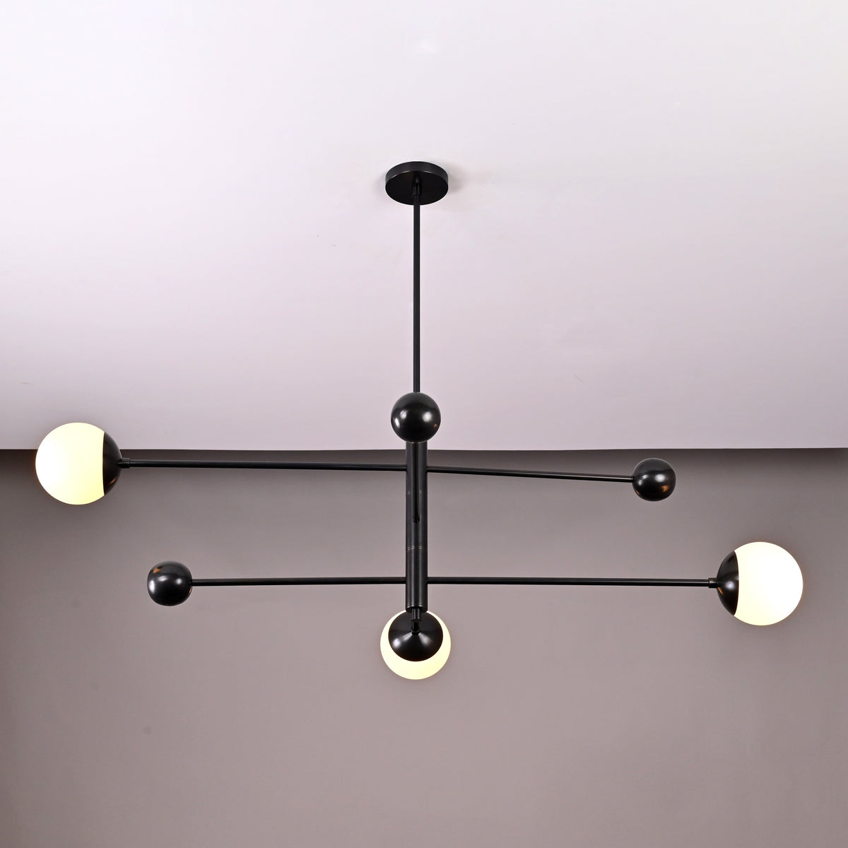 Contemporary 3-light black brass chandelier with spherical opal glass globes – side angle