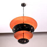 Large top bowl shade of blackened brass pendant showing copper interior glow