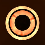 Illuminated blackened brass pendant light showing glowing copper interior
