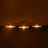 Three lit light bulbs hanging from a ceiling in a dark setting