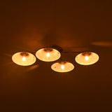 Ceiling light fixture with four round lights on a dark background
