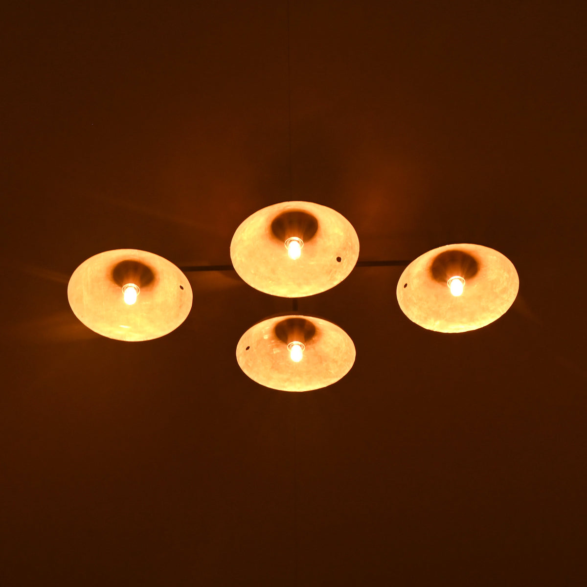 Four lit candles on a dark background