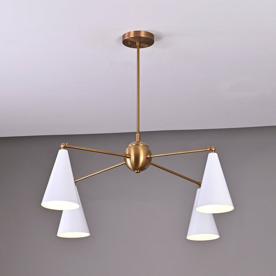 Brass chandelier featuring four white cone shades and a central brass sphere, modern mid-century design.