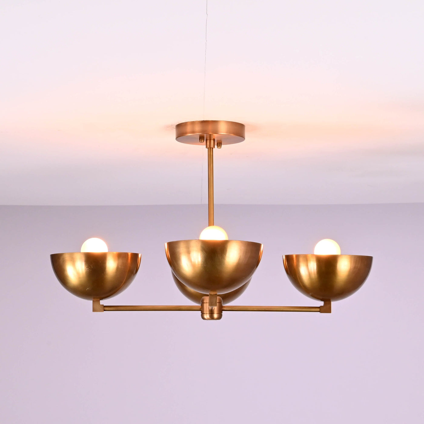 Front view of a handcrafted 4 bowl brass chandelier in brushed brass finish, featuring a minimalist flush mount ceiling design with warm ambient lighting.