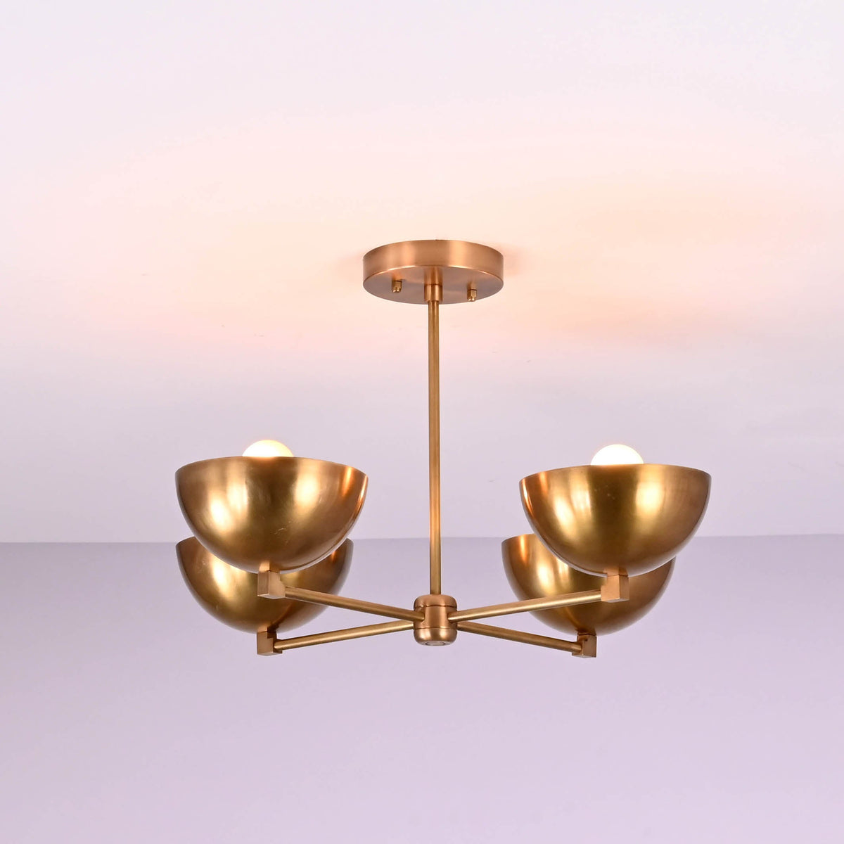 Side profile of a brushed brass 4 bowl chandelier displaying its clean horizontal arm structure and softly curved brass shades.