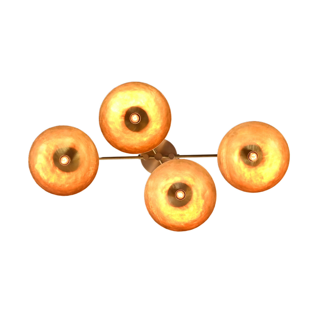 Bottom view of 4 disc brass flush mount ceiling light illuminated with warm ambient glow and handcrafted brass shades