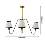 4-light brass chandelier with cream fabric shades and black trim shown illuminated with warm ambient glow