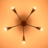 Illuminated 5-light brass cone chandelier casting warm ambient light with mid-century style elegance, ideal for refined home and commercial interiors.