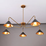 Angled view of modern 5-light brass cone chandelier with warm illumination and sleek sculptural brass frame.