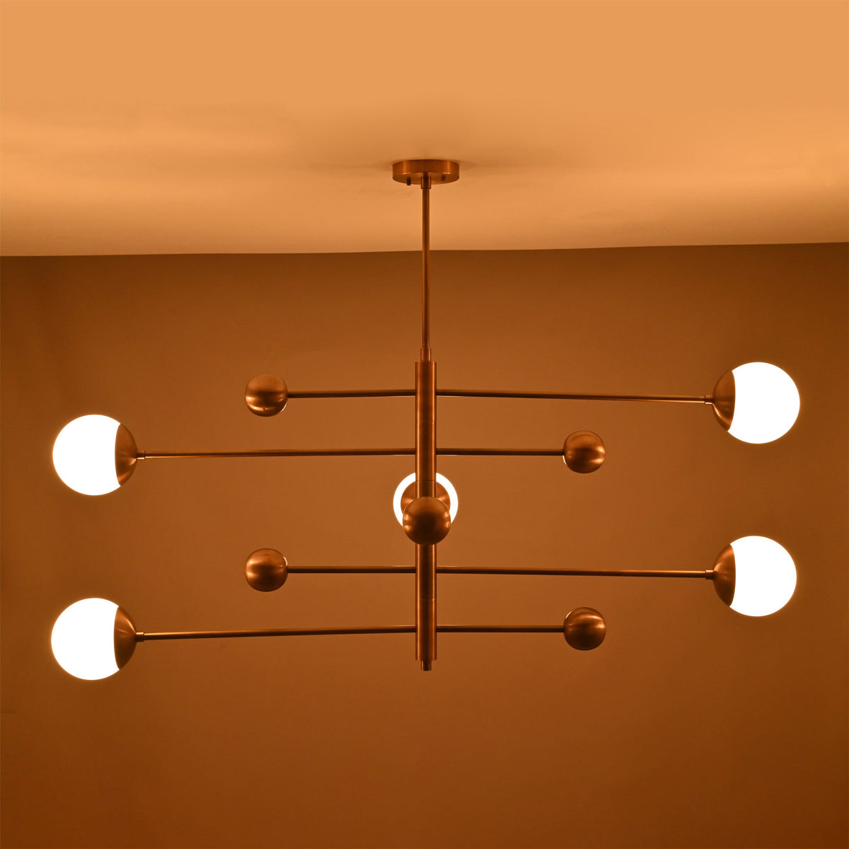 Five light linear ceiling fixture with illuminated opal globes and warm ambient glow for refined interiors