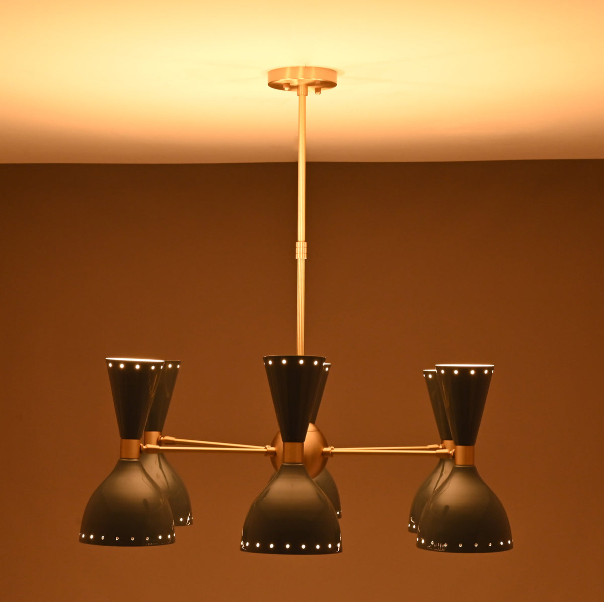 Moody lighting view of 6 Brass Diabolo 12-light chandelier with warm glow and luxury handcrafted brass finish