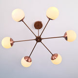 Bottom view of 6 light glass globe brass chandelier showing symmetrical brass arms and warm ambient lighting