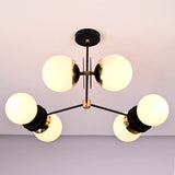 Close-up detail of opal glass globe shades and solid brass hardware on a modern industrial chandelier.