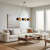 Modern multi-light chandelier with four black spherical shades and four brushed gold conical reflectors, suspended by black cords from a round ceiling canopy on a white background.