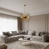 A mid-century modern sushbire-style pendant light in polished brass with two white globe bulbs, suspended against a solid white background.