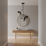 A modern black dual-light pendant ceiling fixture with two adjustable conical shades suspended from a round ceiling canopy on a plain white background.