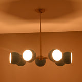 Symmetrical 7 bowl brass chandelier with blue glass shades installed in contemporary space
