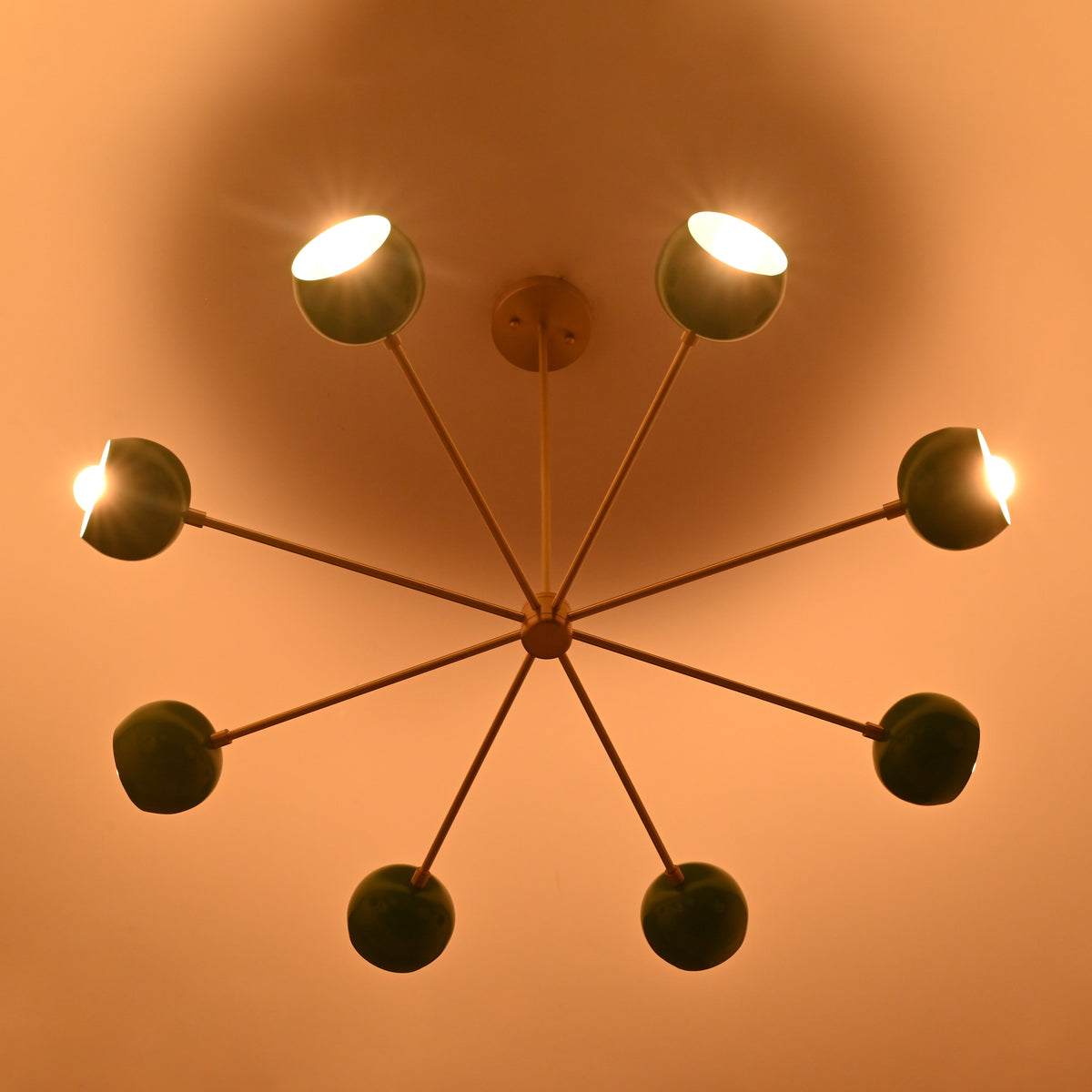 7 bowl green brass chandelier illuminated with warm ambient light creating soft indirect ceiling glow