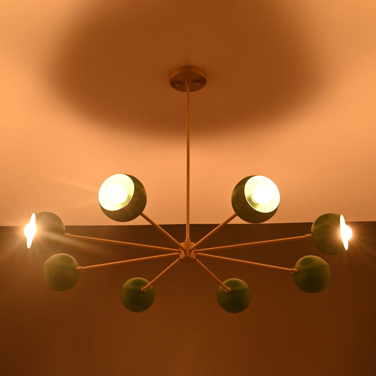Installed 7 bowl green brass sputnik chandelier creating warm modern lighting for dining and living spaces