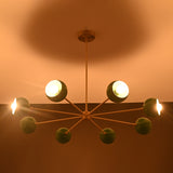 Installed 7 bowl green brass sputnik chandelier creating warm modern lighting for dining and living spaces
