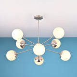 Modern 8 light brass globe chandelier with opal glass shades and balanced mid century silhouette
