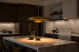 2-tier brass disc chandelier shown illuminated with golden reflected light and sculptural circular shade design