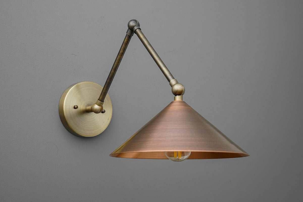 Articulating brass wall sconce with long swing arm and cone shade, mid century inspired adjustable wall lamp in brushed brass tones.