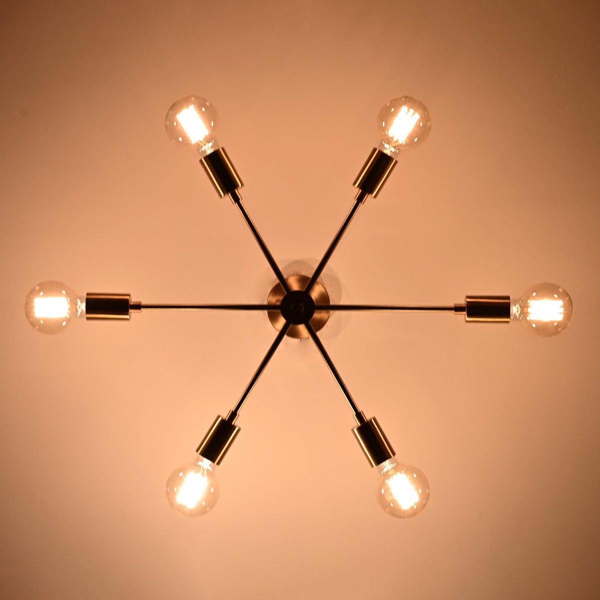 Bottom view of Athens Sputnik six-light ceiling fixture with glowing bulbs and symmetrical starburst arrangement.