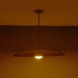 Side view of Aurelia Globe Saucer Pendant Light showing low saucer silhouette and downward warm glow.